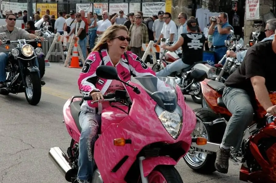 Woman rides pink sport bike down Main Street in Daytona during Bike Week